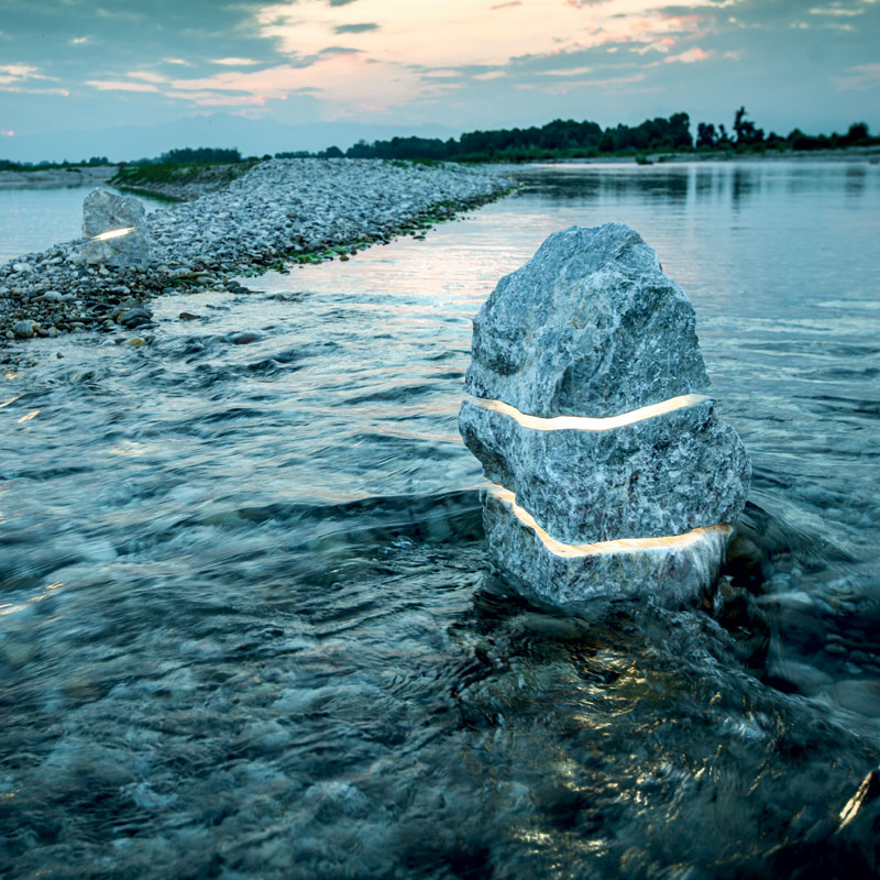 Sculpture en pierre éclairée au bord de l’eau